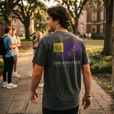 College student wearing fraternity grey t-shirt with colorful flag design on back