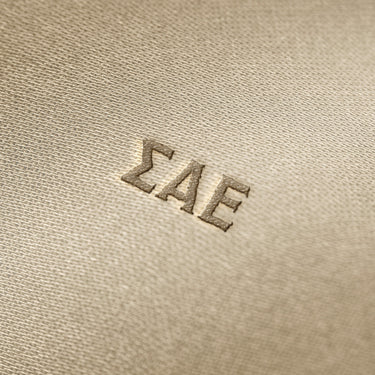 Soft beige fabric close-up showing a smooth, heavyweight knit texture with gentle folds and subtle draping.