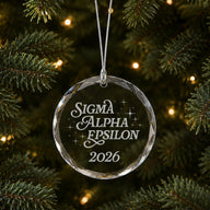 Limited Edition glass Christmas ornament with engraved design hanging on a decorated holiday tree